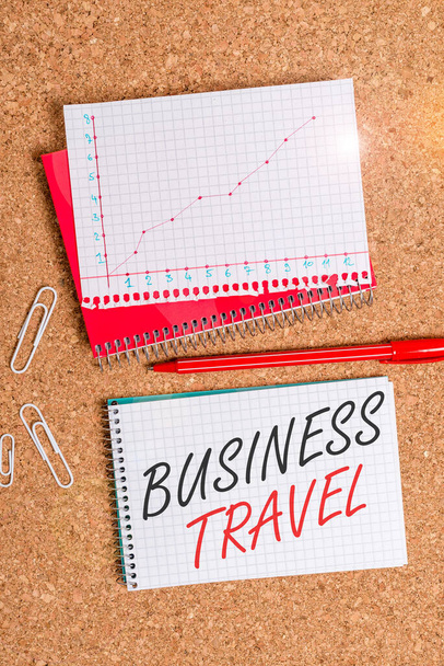Text sign showing Business Travel. Business photo showcasing travel on behalf of a company to one or more destinations Desk notebook paper office cardboard paperboard study supplies table chart - Photo, Image