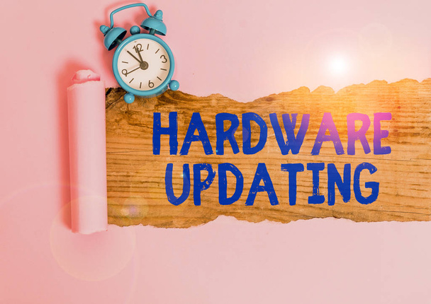 Word writing text Hardware Updating. Business photo showcasing process of replacing a product with a newer version Alarm clock and torn cardboard placed above a wooden classic table backdrop - 写真・画像
