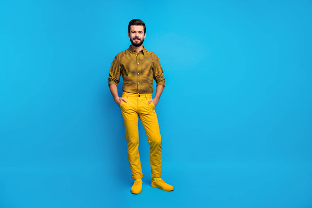 Full size photo of content candid guy enjoy spring free time holiday put hands pocket wear stylish colorful outfit footwear isolated over vibrant color background - Foto, immagini