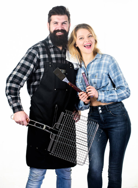 Tools for roasting meat outdoors. Picnic and barbecue. Bearded hipster and girl ready for barbecue party. Roasting and grilling food. Cooking together. Couple in love hold cooking utensils barbecue - Foto, immagini
