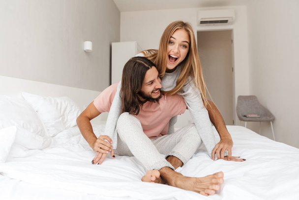 Loving couple in bed hugging indoors at home. - Foto, afbeelding