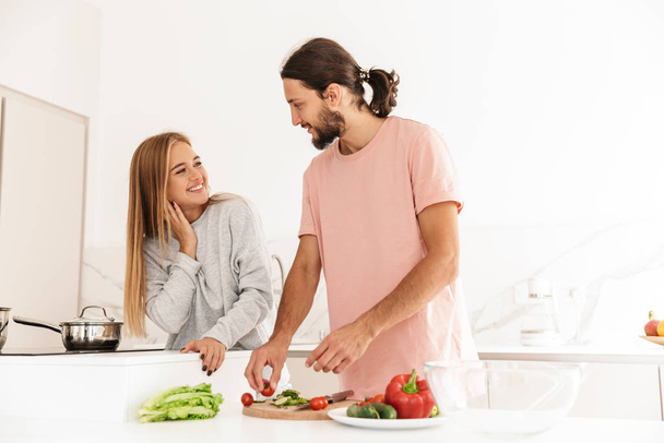 Cheerful lovely couple cooking healthy meal together - Foto, imagen