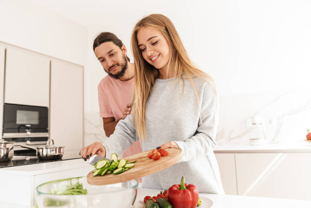 Cheerful lovely couple cooking healthy meal together - Photo, Image