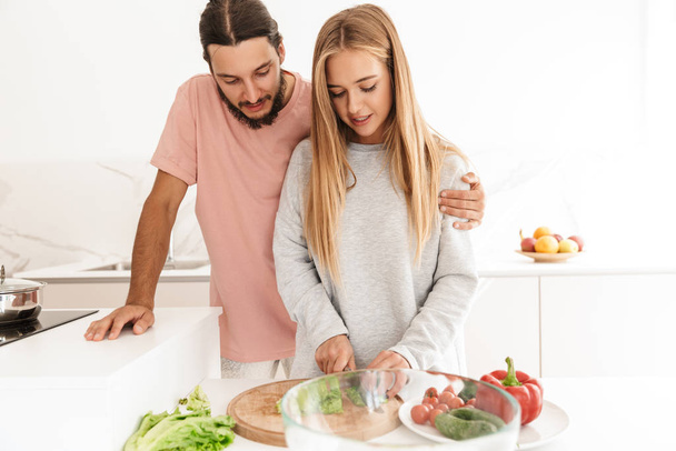 Cheerful lovely couple cooking healthy meal together - Foto, Bild