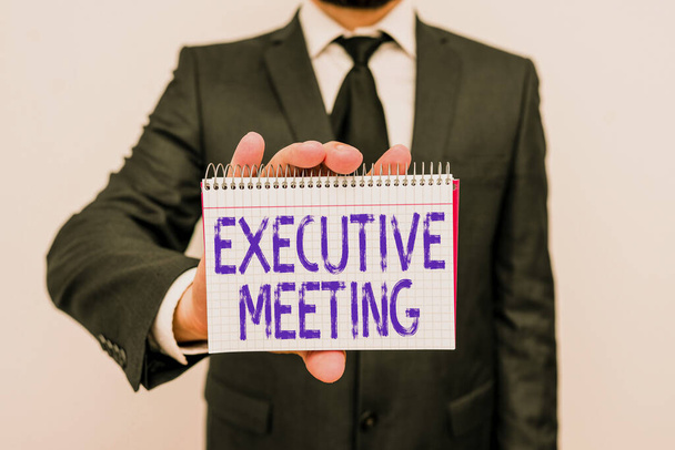 Handwriting text writing Executive Meeting. Concept meaning discuss a specific topic with boards and general members Male human wear formal work suit office look hold mathematics book use hand. - Photo, Image
