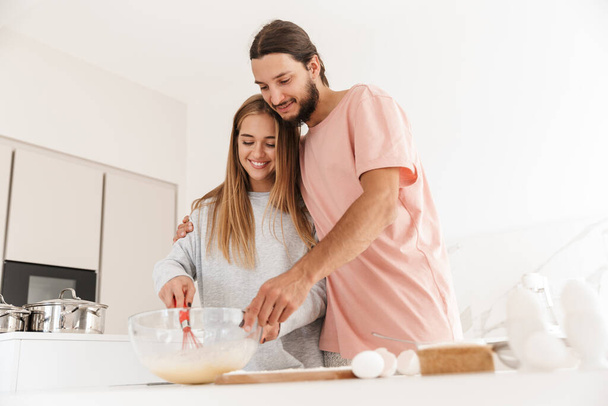 Young loving couple at the kitchen indoors at home - Foto, imagen