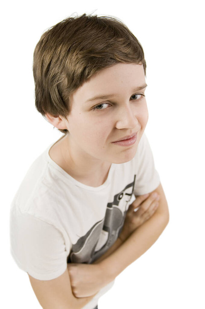upper body portrait of a young male teenagers in t-shirt and arms crossed against white background smiling at the camera from an elevated view - Foto, imagen