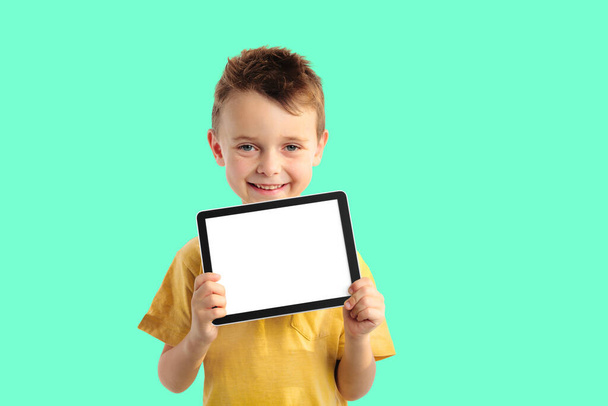 Happy child boy  holding a tablet for your information on the bl - Foto, Imagem
