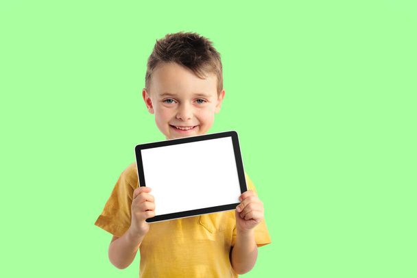 Happy child boy  holding a tablet for your information on the bl - Φωτογραφία, εικόνα