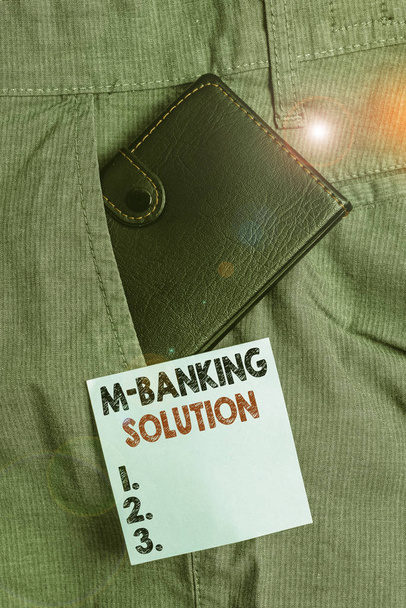 El yazısı M Bankacılık Çözümü. Akıllı telefondaki bir uygulama vasıtasıyla bankacılığa erişilen kavramsal fotoğraf, erkek pantolonunun içindeki küçük cüzdan, not kağıdının yanındaki ön cepte. - Fotoğraf, Görsel