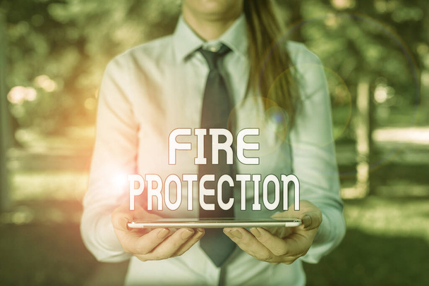 Textschild mit dem Brandschutz. konzeptionelle Fotomaßnahmen, um zu verhindern, dass das Feuer zu einer zerstörerischen Geschäftsfrau im Hemd mit Krawatte und Laptop-Handy in der Hand wird. - Foto, Bild