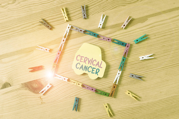 Text sign showing Cervical Cancer. Business photo text type of cancer that occurs in the cells of the cervix Colored clothespin papers empty reminder wooden floor background office - Photo, Image