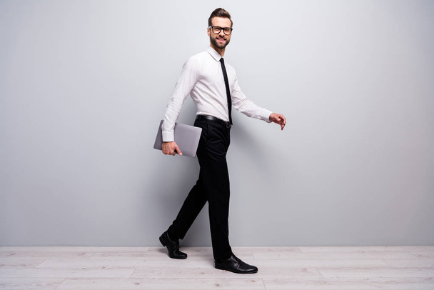 Full size profile side of confident cool entrepreneur man go walk partnership briefing hold computer isolated over white grey color background - Foto, Imagem