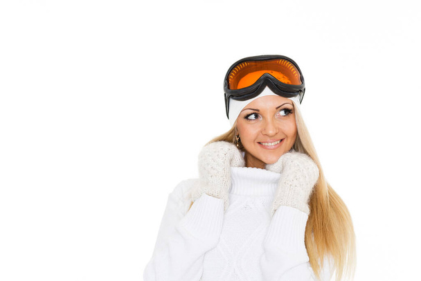 Jonge vrolijke vrouw in de winter warme kleren en skibril staat op een witte achtergrond. Wintersport. - Foto, afbeelding