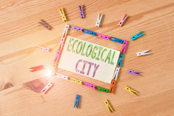Word writing text Ecological City. Business photo showcasing huanalysis settlement modeled on the self sustaining structure Colored clothespin papers empty reminder wooden floor background office - 写真・画像