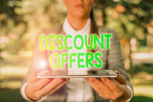 Writing note showing Discount Offers. Business photo showcasing amount or percentage deducted from the normal selling price Outdoor scene with business woman holds lap top with touch screen. - Photo, Image