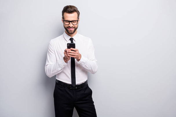 Portrait of positive cheerful clerk man use his smartphone have online conversation with colleagues partnership wear black white outfit isolated over grey color background - Photo, Image