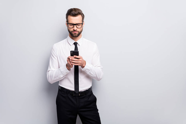 Photo of handsome young macho business man holding telephone reading partners email wear specs white office shirt black tie trousers isolated grey color background - Foto, Imagen