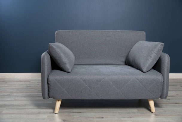 Gray soft sofa with 2 pillows. Modern design sofa  on blue backg - Φωτογραφία, εικόνα