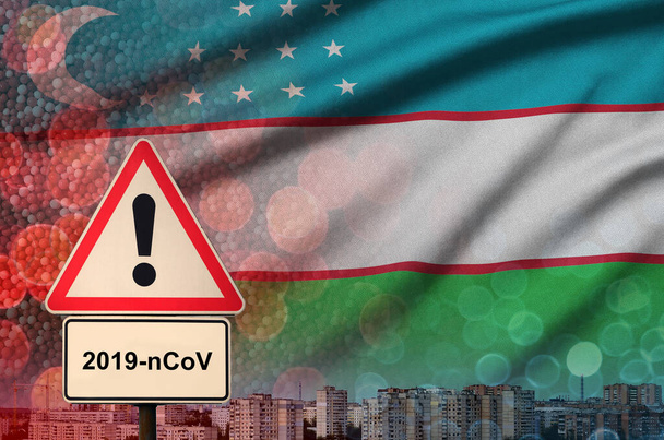 Bandera de Uzbekistán y señal de alerta Coronavirus 2019-nCoV. Concepto de alta probabilidad de brote novedoso de coronavirus a través de turistas viajeros
 - Foto, Imagen