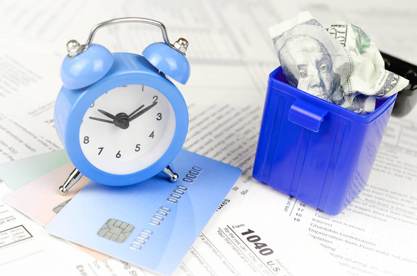 Formulario de impuestos 1040 con despertador azul en tarjetas de crédito y arrugado
 - Foto, imagen