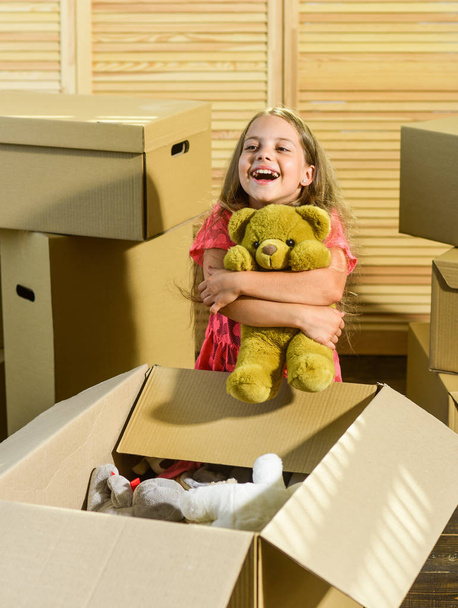 Urban Location. happy little girl with toy. purchase of new habitation. Moving concept. new apartment. happy child cardboard box. Cardboard boxes - moving to new house - Photo, image