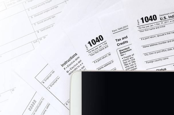 A smartphone fekszik az adó formájában 1040 és a W-2. A szöveg elhelyezkedését tiszta fekete képernyő smartphone - Fotó, kép