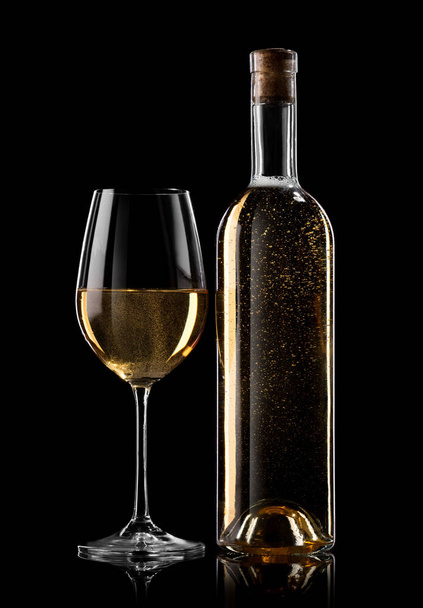 Bottle and glass of white wine on a black background - Фото, зображення