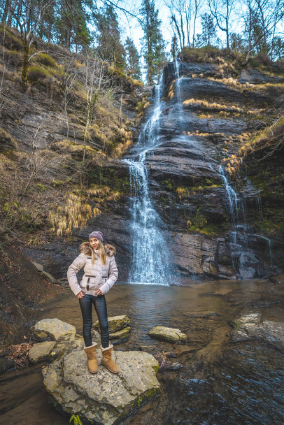 portrait of young woman near waterfall - 写真・画像