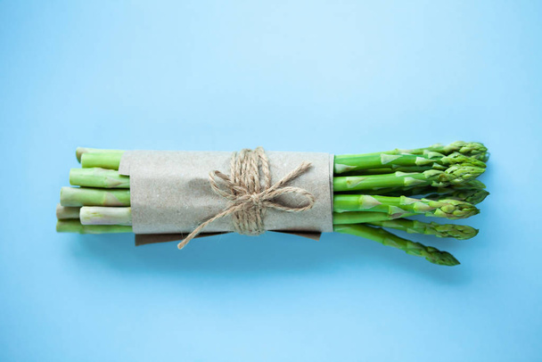 mazzo di asparagi verdi freschi su fondo blu
 - Foto, immagini