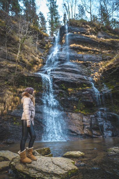 portrait of young woman near waterfall - 写真・画像