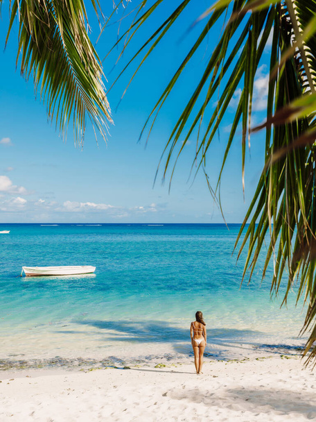 Jeune femme en bikini se détendre à la plage de palmiers tropicaux. Vac tropical
 - Photo, image
