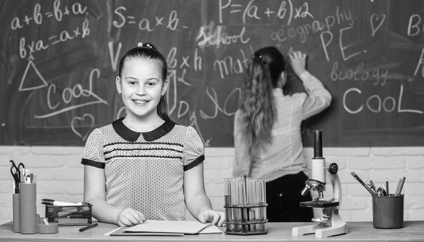 Checking the results. Little scientist work with microscope. Biology school lesson. science experiments in laboratory. Chemistry research. Little girls in school lab. Formal school education - Φωτογραφία, εικόνα