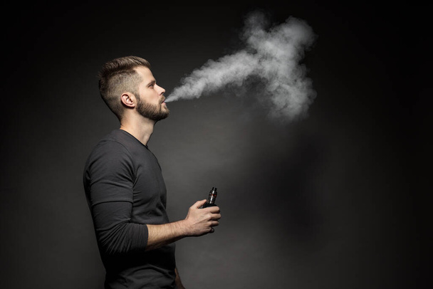 Vaping e-liquid from an electronic cigarette - Foto, afbeelding