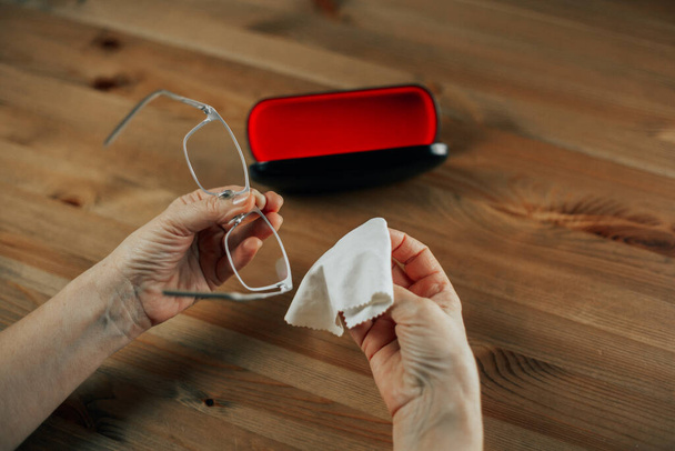 Lunettes sales, main de femme nettoyant soigneusement les lunettes par un chiffon
, - Photo, image