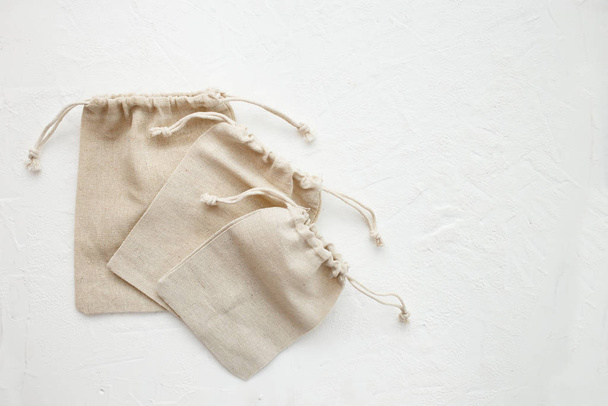 Полотно сумки з стрункою, макет невеликого еко-мішка з натуральної бавовняної тканини плоскі на білому тлі. Плоский прошарок, вид зверху
. - Фото, зображення