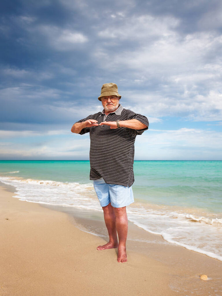 Casual senior man doing exercise on beach - Foto, imagen