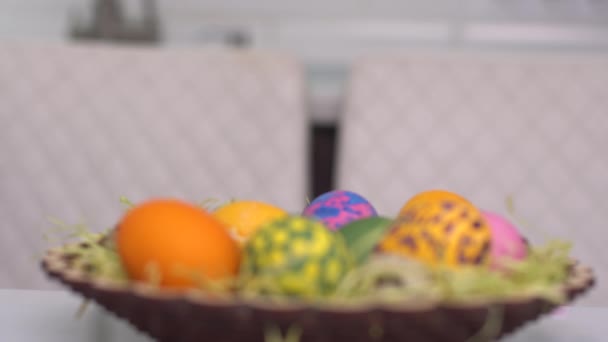 Feliz Pascua. Una niña con orejas de conejo aparece detrás de los huevos de Pascua. Felices hijos de familia preparándose para Pascua. Linda niña pequeña con orejas de conejo en el día de Pascua
 - Imágenes, Vídeo