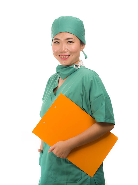 jeune belle et confiante asiatique médecine coréenne médecin ou infirmière de l'hôpital femme souriant heureux tenant rapports médicaux presse-papiers portant chapeau de chirurgien et gommages dans le concept de soins de santé
  - Photo, image