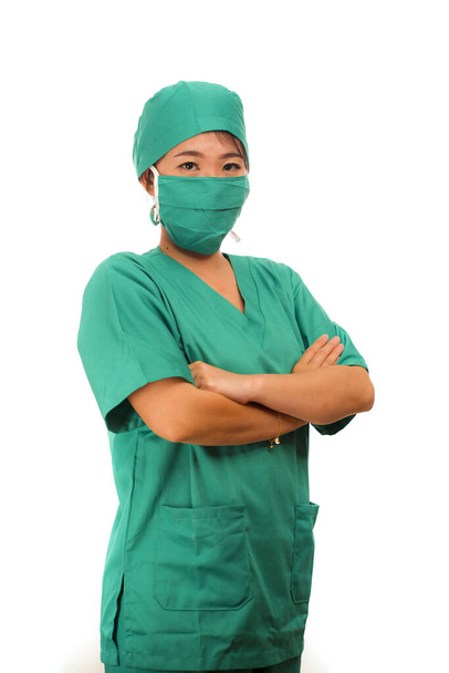 Asian Chinese woman as successful physician - young beautiful and attractive medicine doctor or chief hospital nurse in scrubs and surgeon hat smiling behind surgical mask - Photo, Image