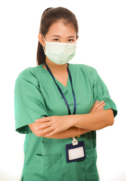 Asian Chinese woman as successful physician - young beautiful and happy medicine doctor or chief hospital nurse in green scrubs and surgeon mask with folded arms  - Foto, immagini