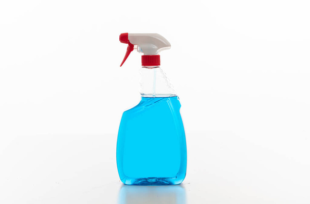 Butelka z sprayem czyszczącym przezroczysta z niebieskim płynem koloru izolowanym na białym tle. - Zdjęcie, obraz