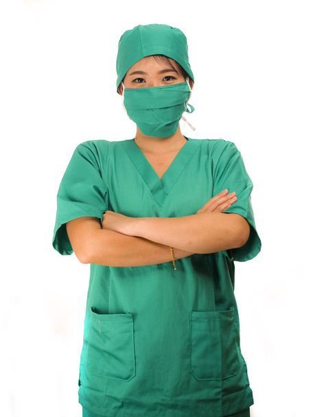 Mujer coreana asiática como médico exitoso - joven médico de medicina hermosa y atractiva o enfermera jefe del hospital en matorrales y sombrero de cirujano sonriendo detrás de la máscara quirúrgica
 - Foto, Imagen
