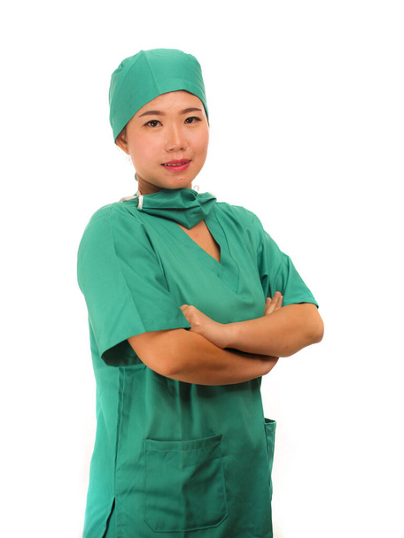 Asian Korean woman as successful physician - young beautiful and happy medicine doctor or chief hospital nurse in green scrubs and surgeon hat smiling confident  - Photo, image