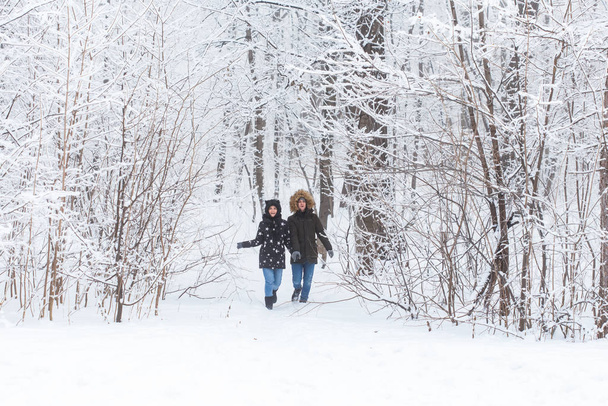 Happy loving couple having fun outdoors in snow park. Winter vacation - Фото, изображение