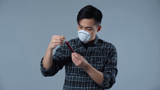 aasialainen mies tilalla koeputki kanssa coronasvirus kirjoitus eristetty harmaa
  - Materiaali, video
