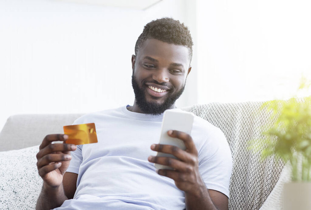 African guy making transaction online using mobile application - Photo, Image