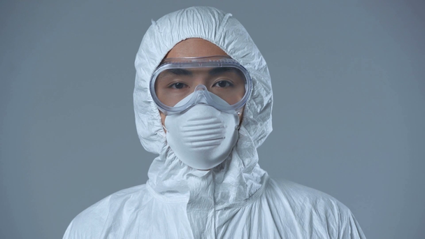 asiatischer Wissenschaftler im Schutzanzug isoliert auf grau  - Filmmaterial, Video