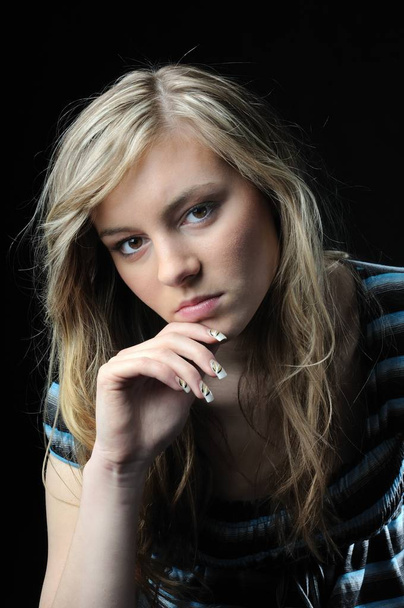 Young sad and thoughtful woman (teenager) isolated on black background - Zdjęcie, obraz