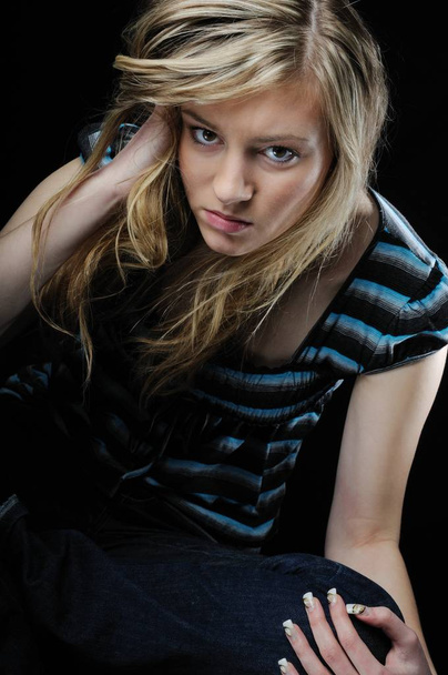 Young beautiful blond depressed woman (teenager)isolated on black background - Photo, Image